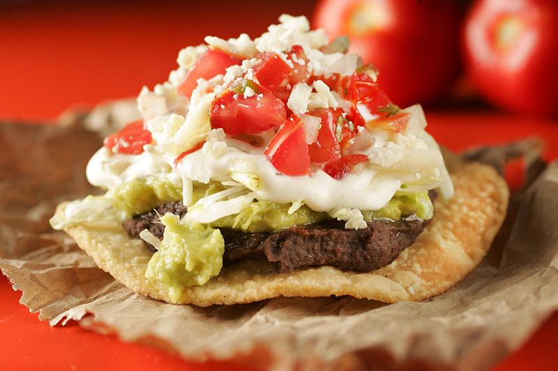 Entre os petiscos para comer com as mãos, está a tostada tradicional de pasta de feijão