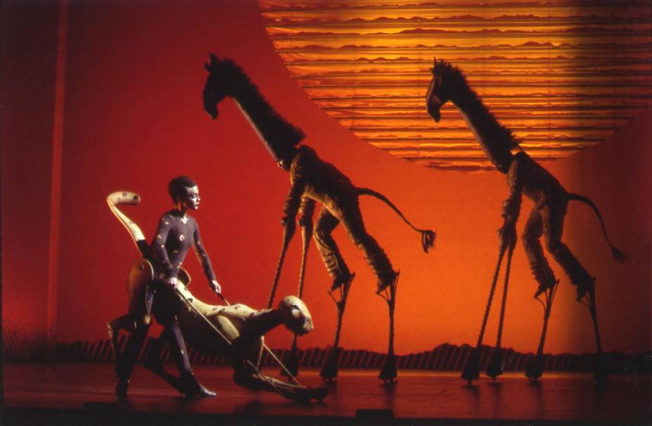Girafas e um guepardo andam pela savana durante a apresentação da música "O Círculo da Vida" (The Tree of Life), que abre o espetáculo. Girafas e um guepardo andam pela savana durante a apresentação da música "O Círculo da Vida" (The Tree of Life), que abre o espetáculo.