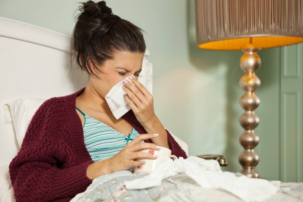 Young woman in bed with cold