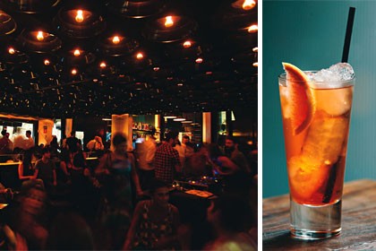 O ambiente com sofás e uma parede espelhada e o coquetel spritz O ambiente com sofás e uma parede espelhada e o coquetel spritz