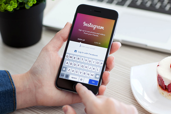 Woman holding iPhone 6 Space Gray with service Instagram