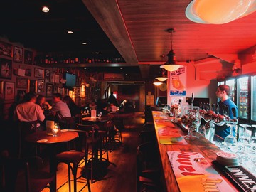 Clima de pub: ambiente de luz baixa e referências à bebida na decoração Clima de pub: ambiente de luz baixa e referências à bebida na decoração