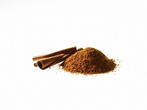 Studio shot of Ground Cinnamon and Cinnamon Sticks on white background