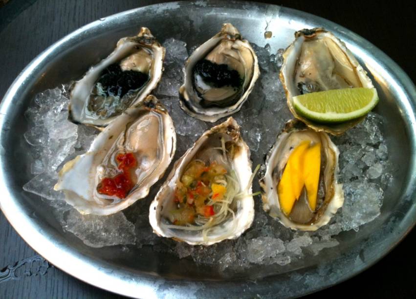 Ostras do Mercadão: com ovas de peixe, limão, geleia de pimenta, vinagrete e manga Ostras do Mercadão: com ovas de peixe, limão, geleia de pimenta, vinagrete e manga