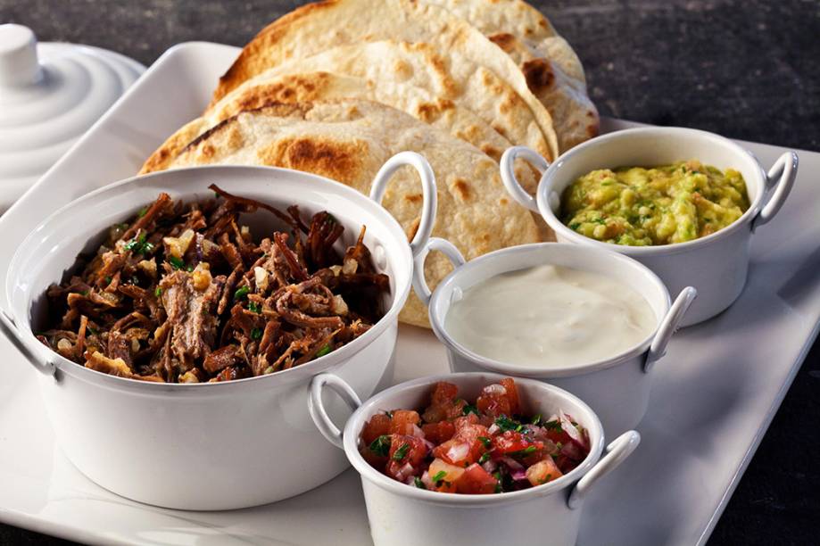 Fajitas mexicanas para serem montadas na mesa vêm com carne desfiada, sour cream, guacamole e salsa pico de galo Fajitas mexicanas para serem montadas na mesa vêm com carne desfiada, sour cream, guacamole e salsa pico de galo