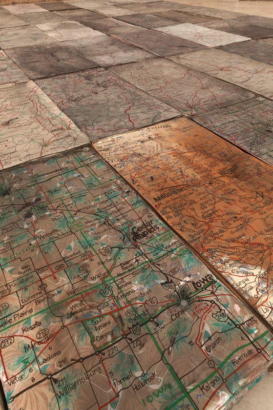 Detalhe da instalação Le Sacre, que traz mapas rodoviários desconexos em minicolchões Detalhe da instalação Le Sacre, que traz mapas rodoviários desconexos em minicolchões