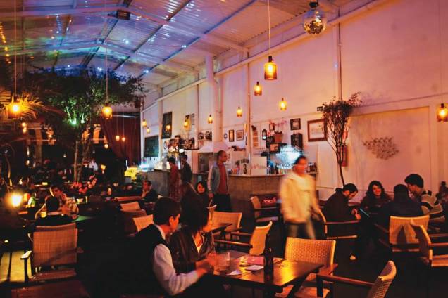 O descontraído ambiente: luminárias feitas com garrafões de vinho e, ao fundo, uma pitangueira O descontraído ambiente: luminárias feitas com garrafões de vinho e, ao fundo, uma pitangueira
