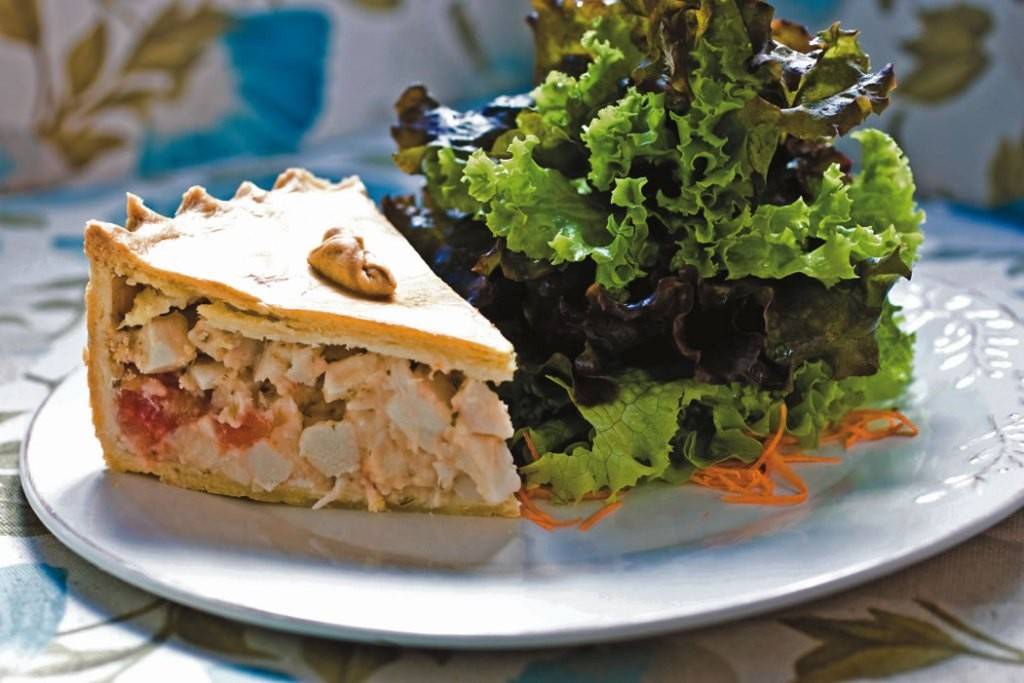 Fatia generosa de torta de palmito e tomate acompanhada de salada Fatia generosa de torta de palmito e tomate acompanhada de salada