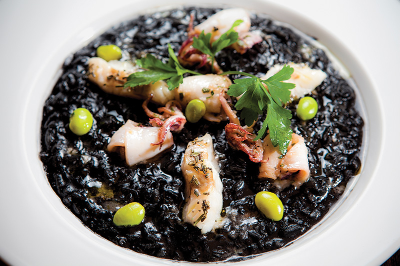 Risoto de tinta de lula com fatias do molusco e merluza Risoto de tinta de lula com fatias do molusco e merluza