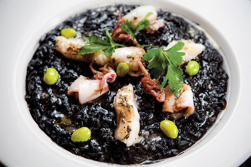 Risoto de tinta de lula com fatias do molusco e merluza Risoto de tinta de lula com fatias do molusco e merluza