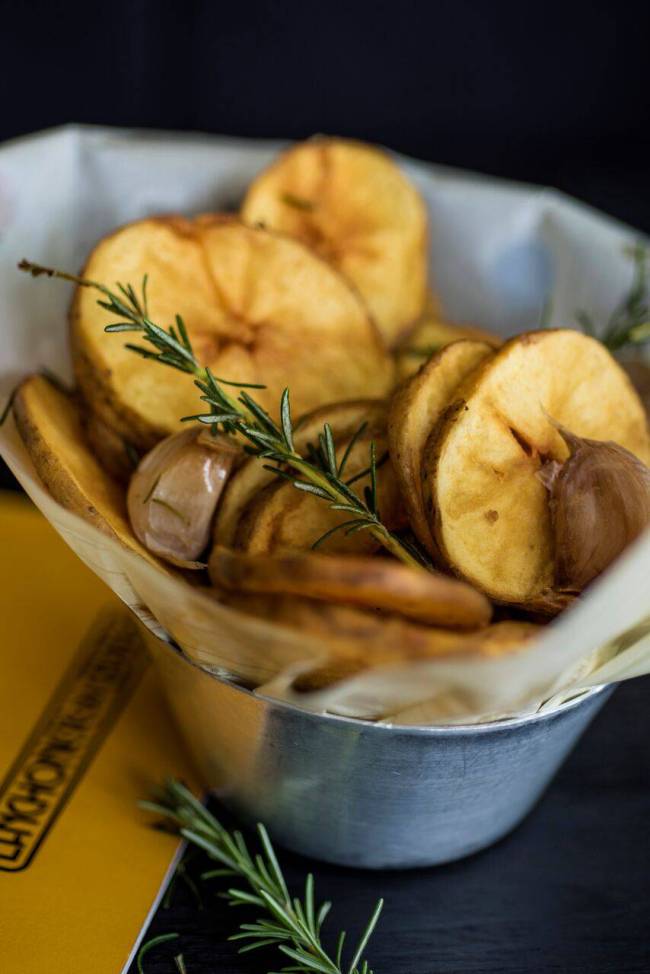 Porção de fritas em rodelas com alho e alecrim.