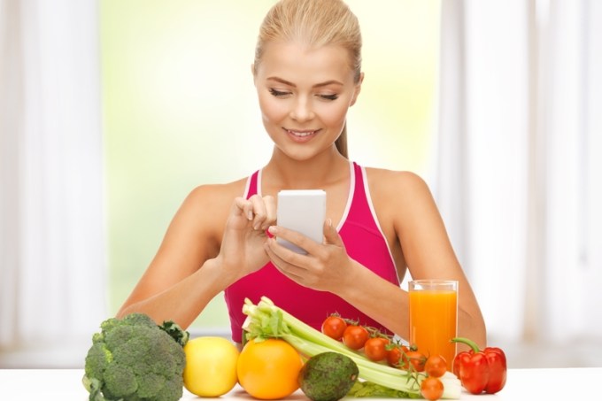 woman with fruits, vegetables and smartphone
