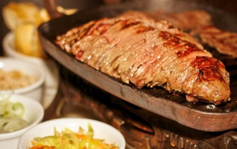 A picanha no réchaud chega na companhia de vinagrete, repolho, cebola no azeite e farofa A picanha no réchaud chega na companhia de vinagrete, repolho, cebola no azeite e farofa