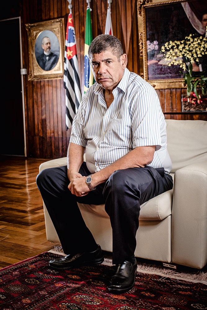 milton leite câmara A imagem mostra MIlton Leite, sentado inclinado para frente em uma poltrona, com cara séria