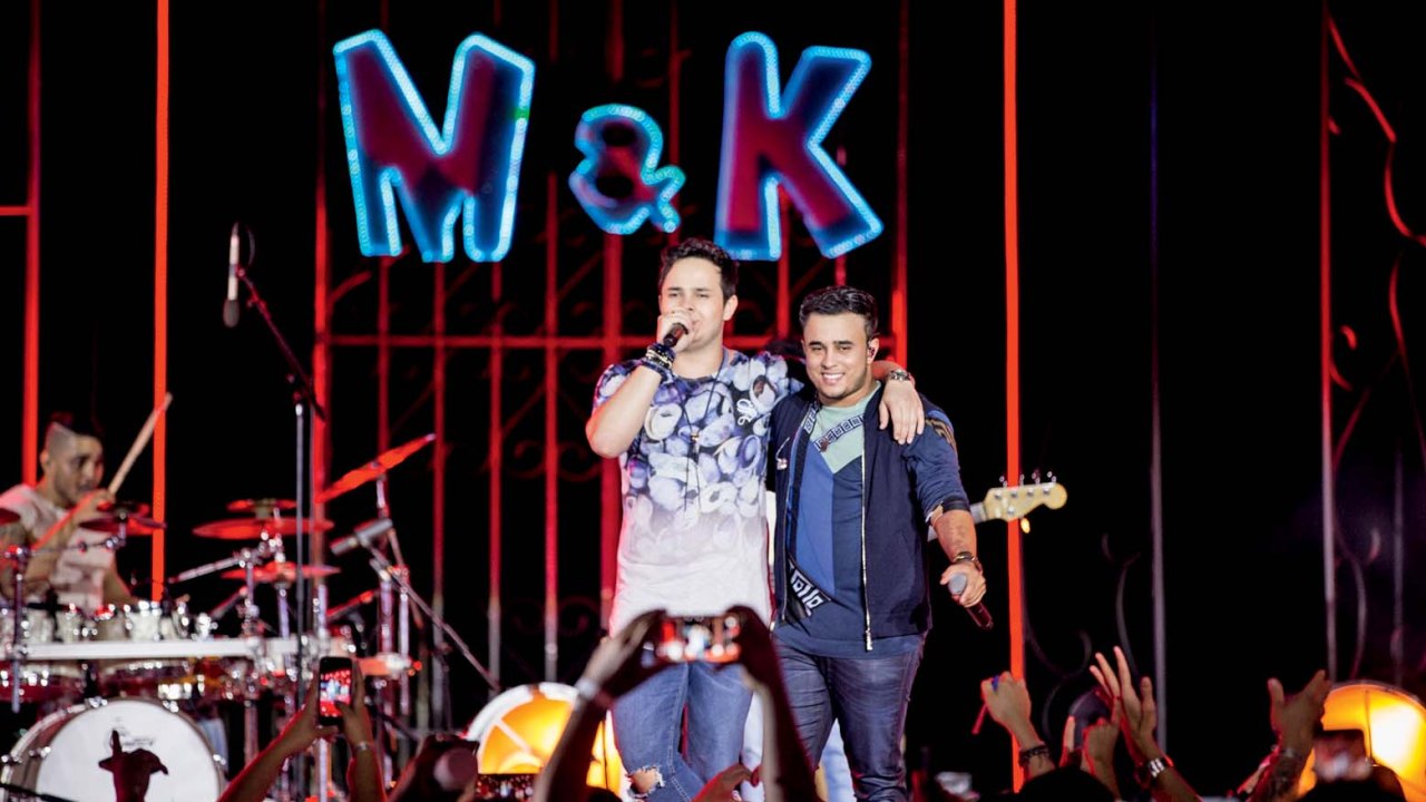Dois homens no palco abraçados