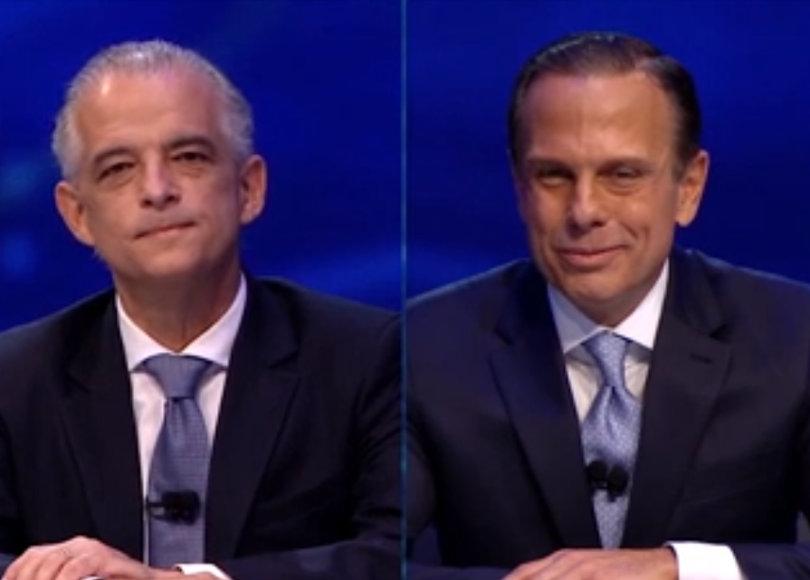 Imagem mostra tela dividida entre Márcio França e João Doria, ambos de terno escuro e gravata azul