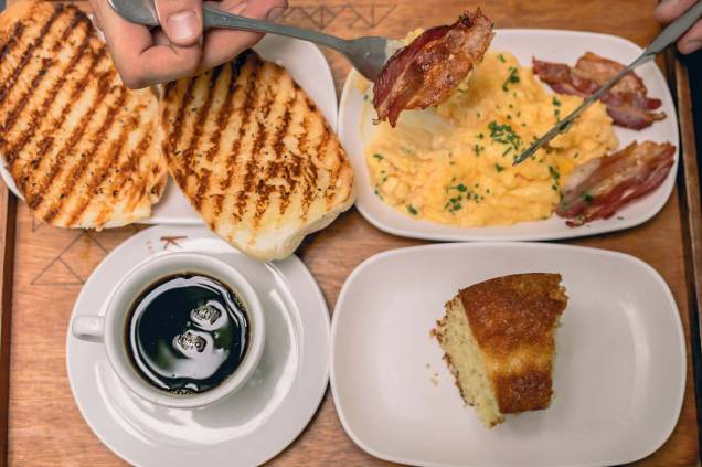 Café da manhã no Mano Sanduíches: combinados como o americano, com expresso, suco natural, baguete na chapa e ovos mexidos com bacon Café da manhã no Mano Sanduíches: combinados como o americano, com expresso, suco natural, baguete na chapa e ovos mexidos com bacon