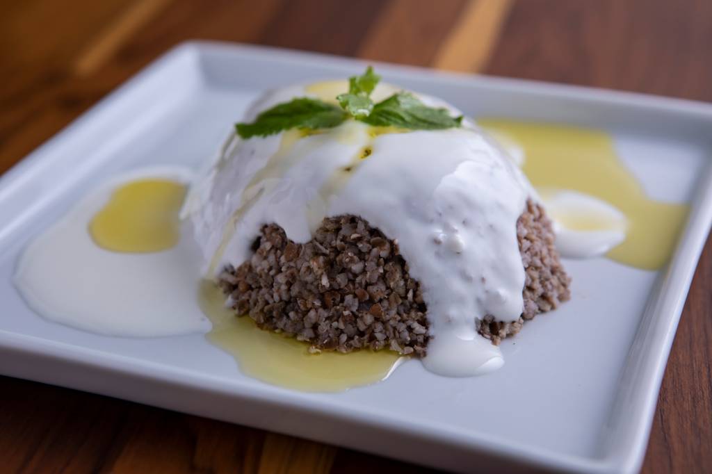 Receita com trigo: os grãos cozidos com carne moída e frango desfiado são banhados em uma generosa quantidade de coalhada fresca Receita com trigo: os grãos cozidos com carne moída e frango desfiado são banhados em uma generosa quantidade de coalhada fresca