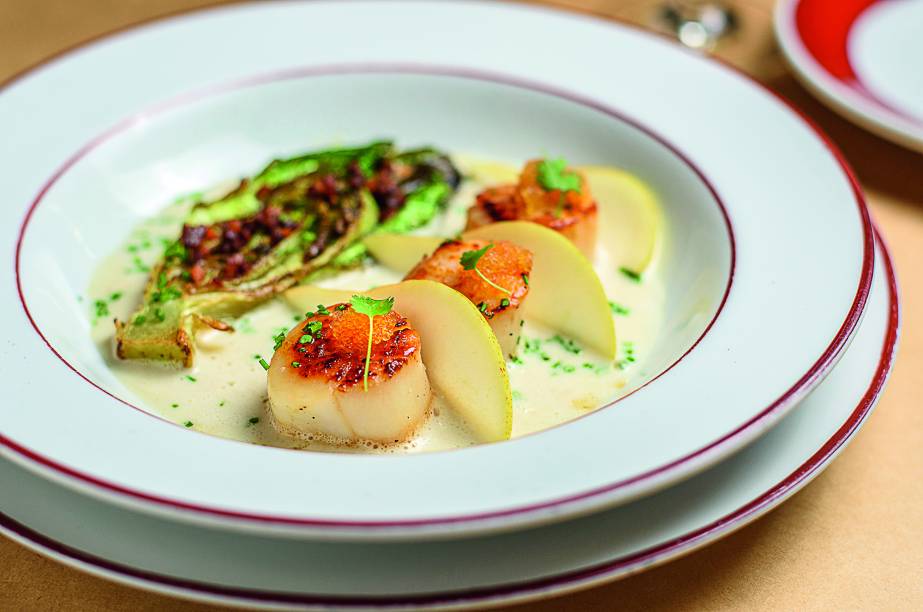 Trio de vieiras: grelhadas e guarnecidas com caldo de peixe ao gengibre, fatias de pera, ovas de peixe-voador, alface-romana grelhada e cubos de bacon