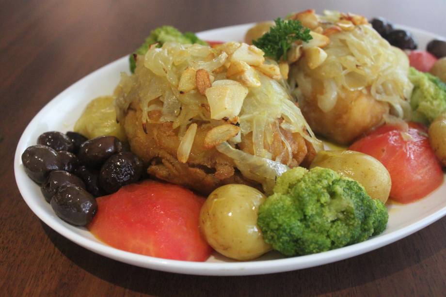 Bacalhau à lagareiro: posta do peixe assada e guarnecida de alho, batatinha ao murro, brócolis, tomate e azeitona