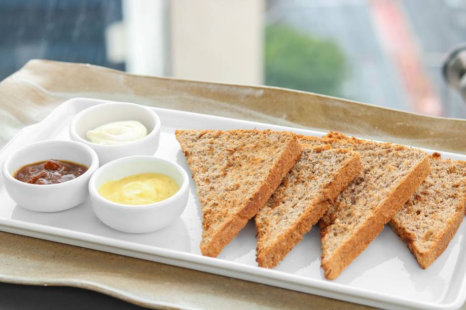 Fatias de pão integral com manteiga com semente de cumaru Fatias de pão integral com manteiga com semente de cumaru