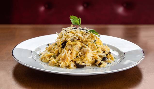 Bacalhau à brás: com batata palha, cebola frita, ovo mexido, azeitona e salsa Bacalhau à brás: com batata palha, cebola frita, ovo mexido, azeitona e salsa