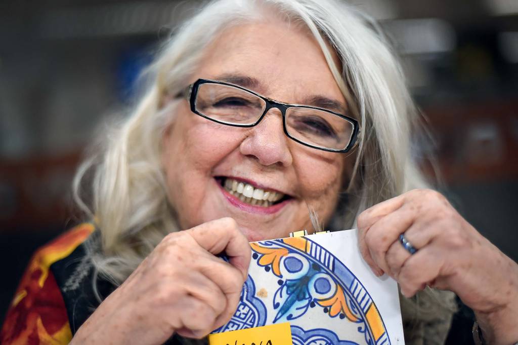 Nina Horta Mulher de cabelos grisalhos lisos e óculos sorrindo.