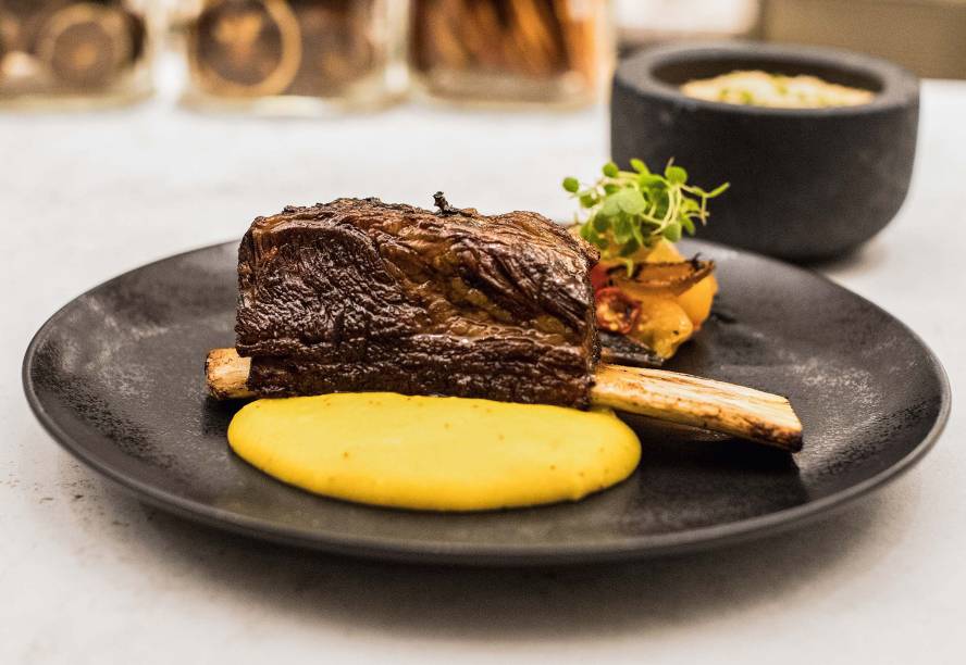 Costela: cozida por dezoito horas, acompanha farofa, purê de banana, vinagrete e ovo cremoso Costela: cozida por dezoito horas, acompanha farofa, purê de banana, vinagrete e ovo cremoso