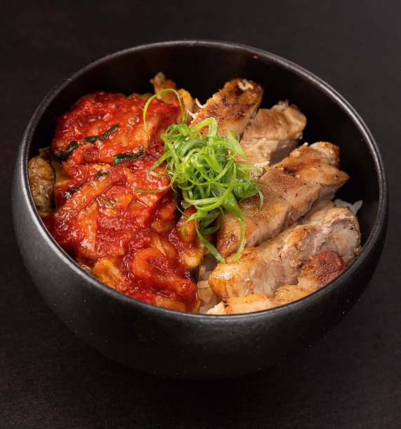 Tigela de arroz: coberta de kichi, a conserva de acelga fermentada e apimentada, e pancetta Tigela de arroz: coberta de kichi, a conserva de acelga fermentada e apimentada, e pancetta