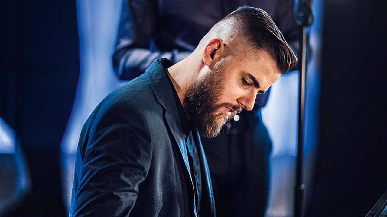 A imagem mostra o cantor Zé Neto no palco