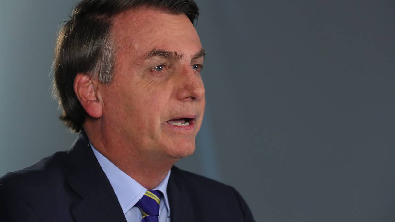 Imagem mostra Bolsonaro, de terno e gravata, olhando para câmera em estúdio de TV, enquanto grava pronunciamento