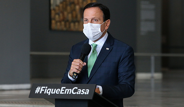 Governador João Doria, de máscara e terno no Palácio dos Bandeirantes durante coletiva de imprensa