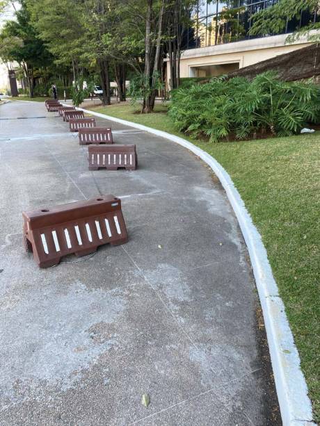 O Parque Cidade Jardim: paredão de garagens para a rua, onde balizas improvisam “calçada” para o pedestre, que não tem espaço nem na rampa O Parque Cidade Jardim: paredão de garagens para a rua, onde balizas improvisam “calçada” para o pedestre, que não tem espaço nem na rampa