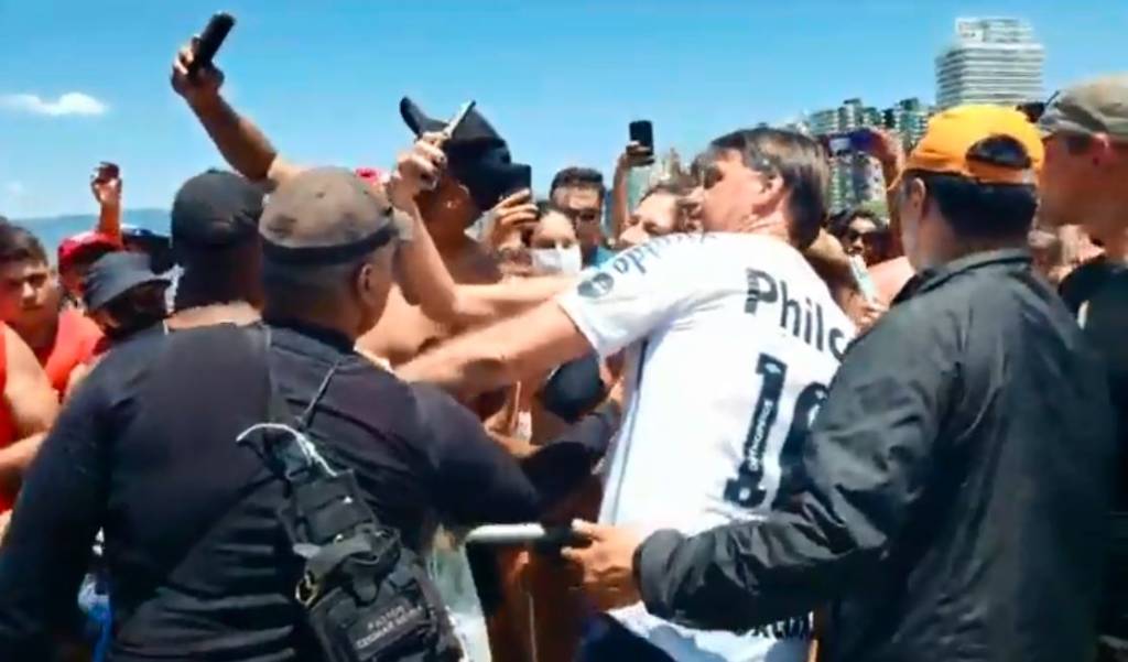 Sem máscara, Bolsonaro pega criança no colo e gera aglomeração em praia