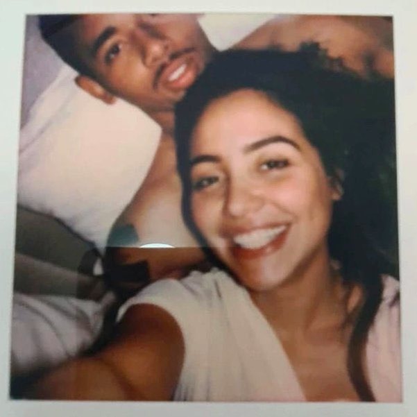 Uma mulher tirando selfie com Gabriel Jesus em uma cama