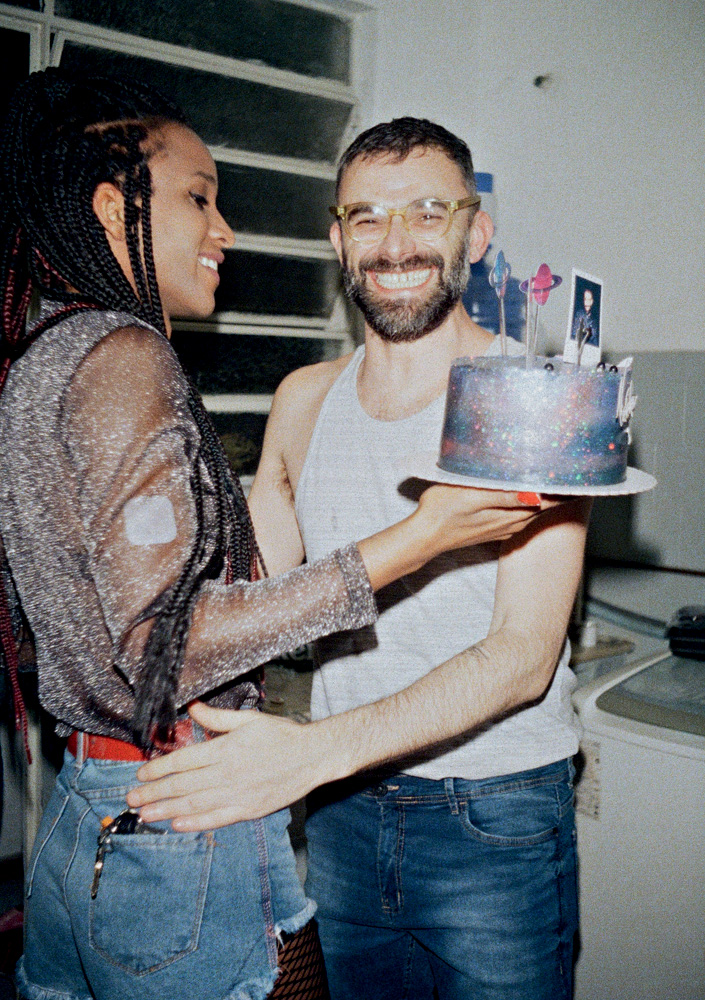 Bárbara Britto e Leo Felipe Bárbara segura um bolo de aniversário quando Leo a abraça