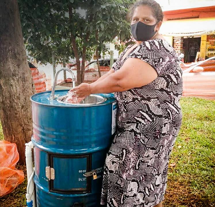 Moradora de Heliópolis lava as mãos em pia instalada em tambor.