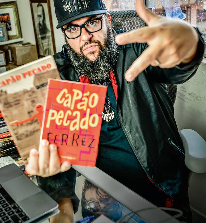 Escritor Ferréz com seu livro na mão, Capão Pecado