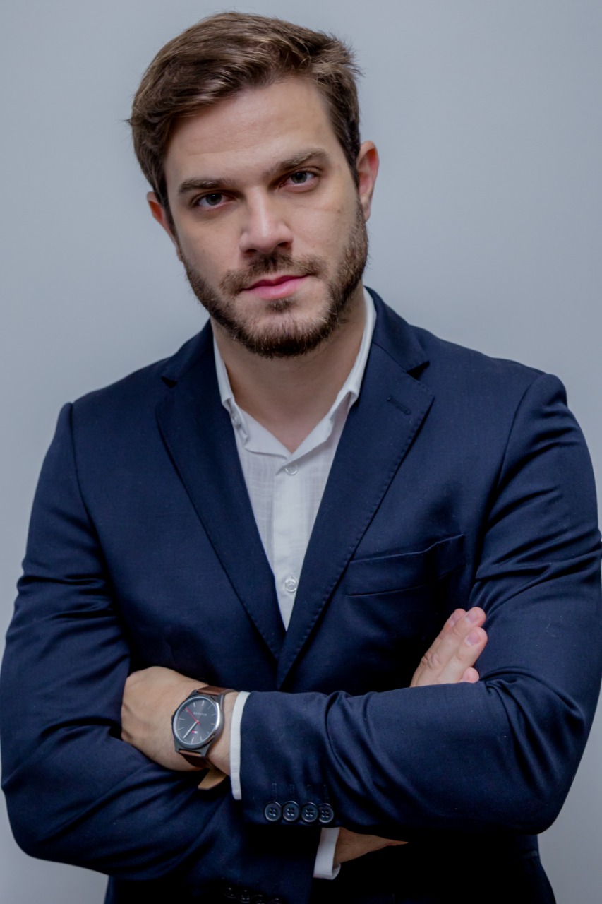 Felipe Becari (Elisa Mancuzo) Vereador Felipe Becari posa de braços cruzados com paletó azul-escuro e relógio no braço esquerdo.