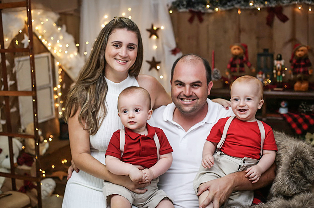1 Roberta Cardoso_1.jpg Roberta com o marido e os dois filhos, todos sentados e rindo em um sofá