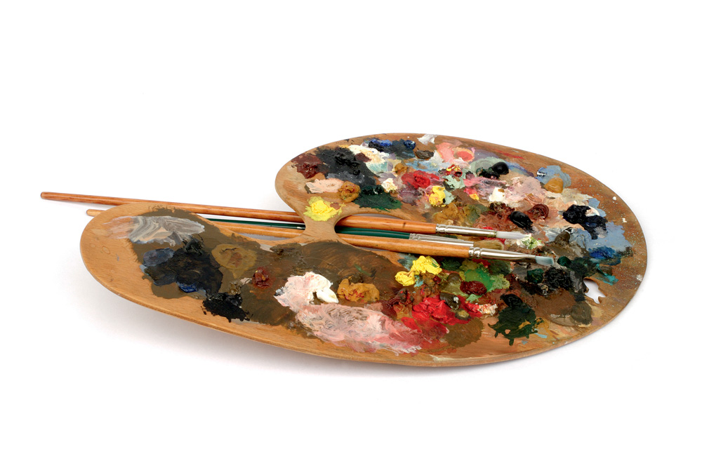 Paleta com tinta e pincéis de varias cores espalhadas