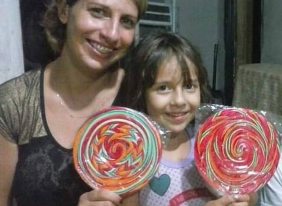 Mãe e filha, as duas com pirulitos nas mãos