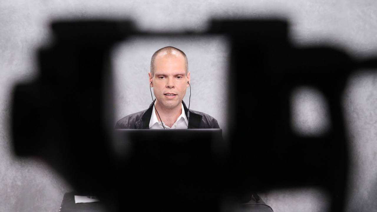 Imagem mostra o prefeito Bruno Covas de fones de ouvido durante uma entrevista on line