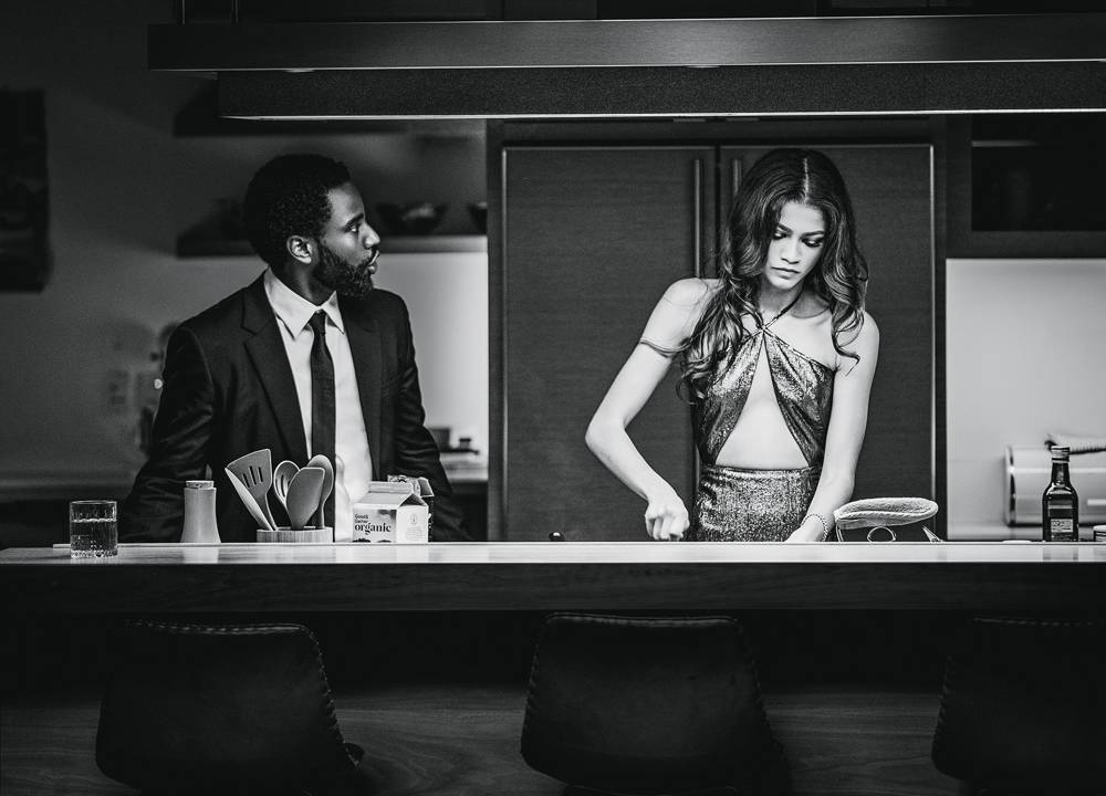 visão de frente da mulher preparando o jantar enquanto seu marido olha para ela, falando