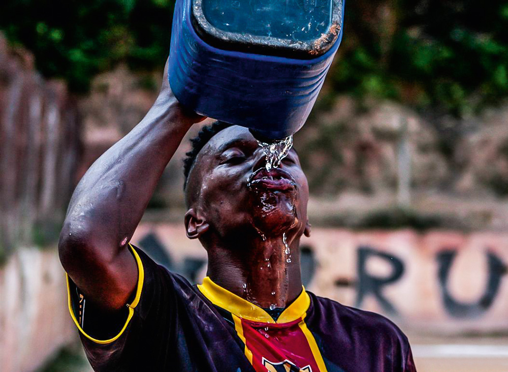 A 14624359_732456800238429_2789845936111616000_n (1).jpg Jogador tomando água com um garrafão de água azul