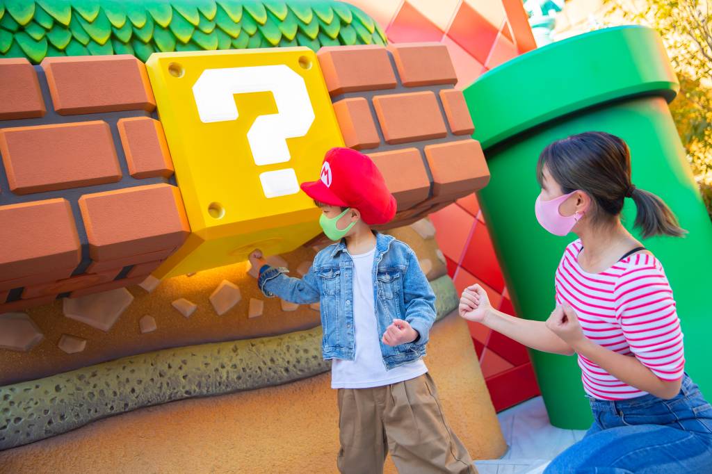 Super Nintendo World parque universal bloco Criança de máscara batendo no bloco do Mario World