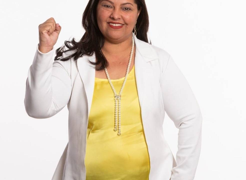 Imagem mostra Marilda Brandão sorrindo exibindo punho cerrado