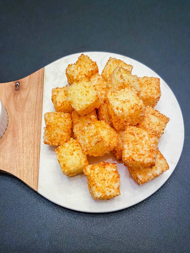 dadinhos de tapioca sobre tábua arrendondada de madeira