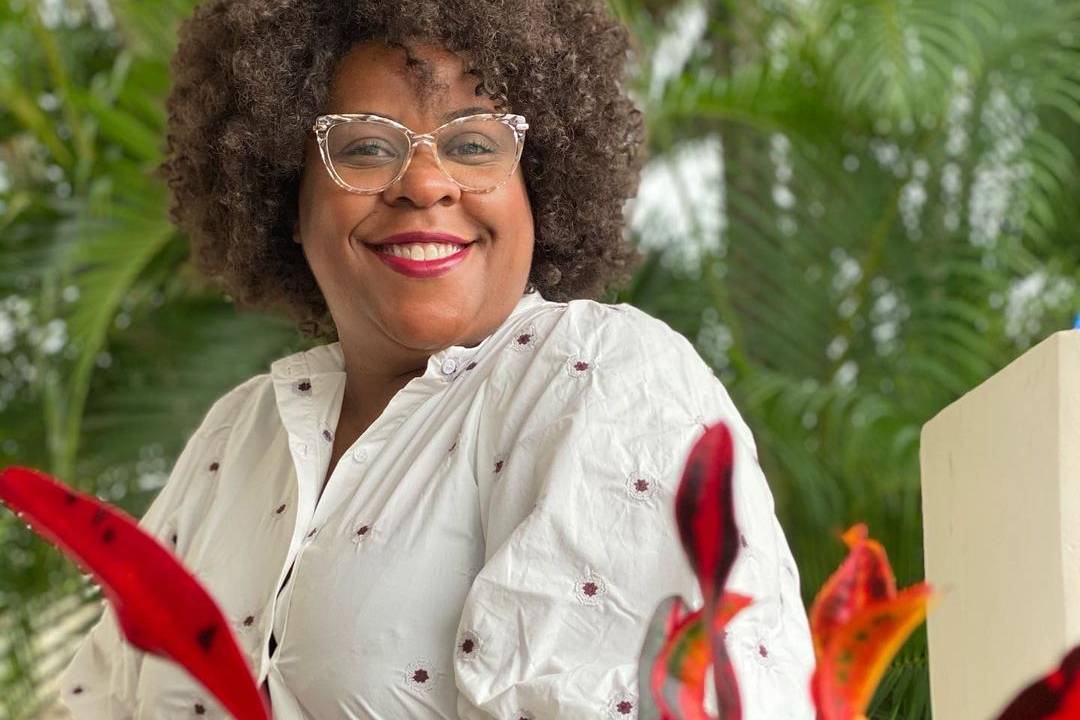 Cacau sorrindo para a câmera, de óculos