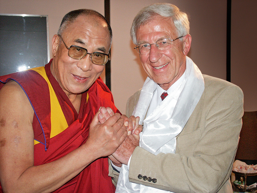 DCF 1.0 Tenzin Gyatso, o 14º Dalai Lama, com o ativista alemão Franz Alt. Eles posam para a foto de mãos dadas em frente ao peito